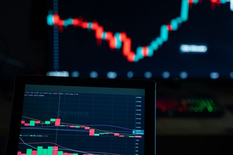 Beginner using a trading simulator on a laptop with virtual portfolio and real-time market data displayed on screen