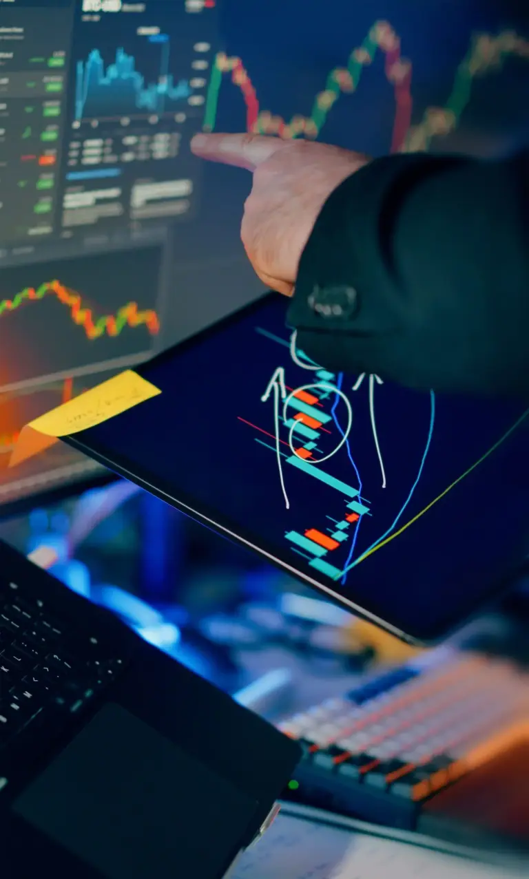 Person at a desk calculating how much money to start investing with a notebook and a small plant symbolising growth