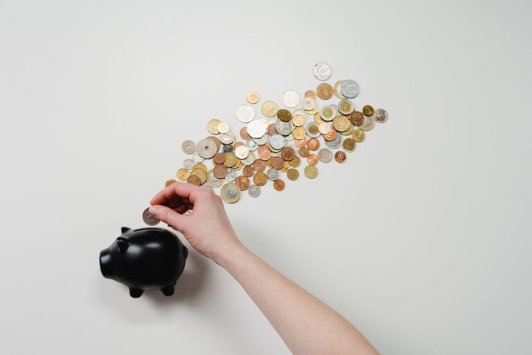 Emergency fund jar filled with coins and banknotes beside a checklist showing how much to save for financial security
